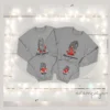 Sudaderas navideñas familiares grises con diseño de gnomos y nombres personalizados sobre fondo blanco con luces.