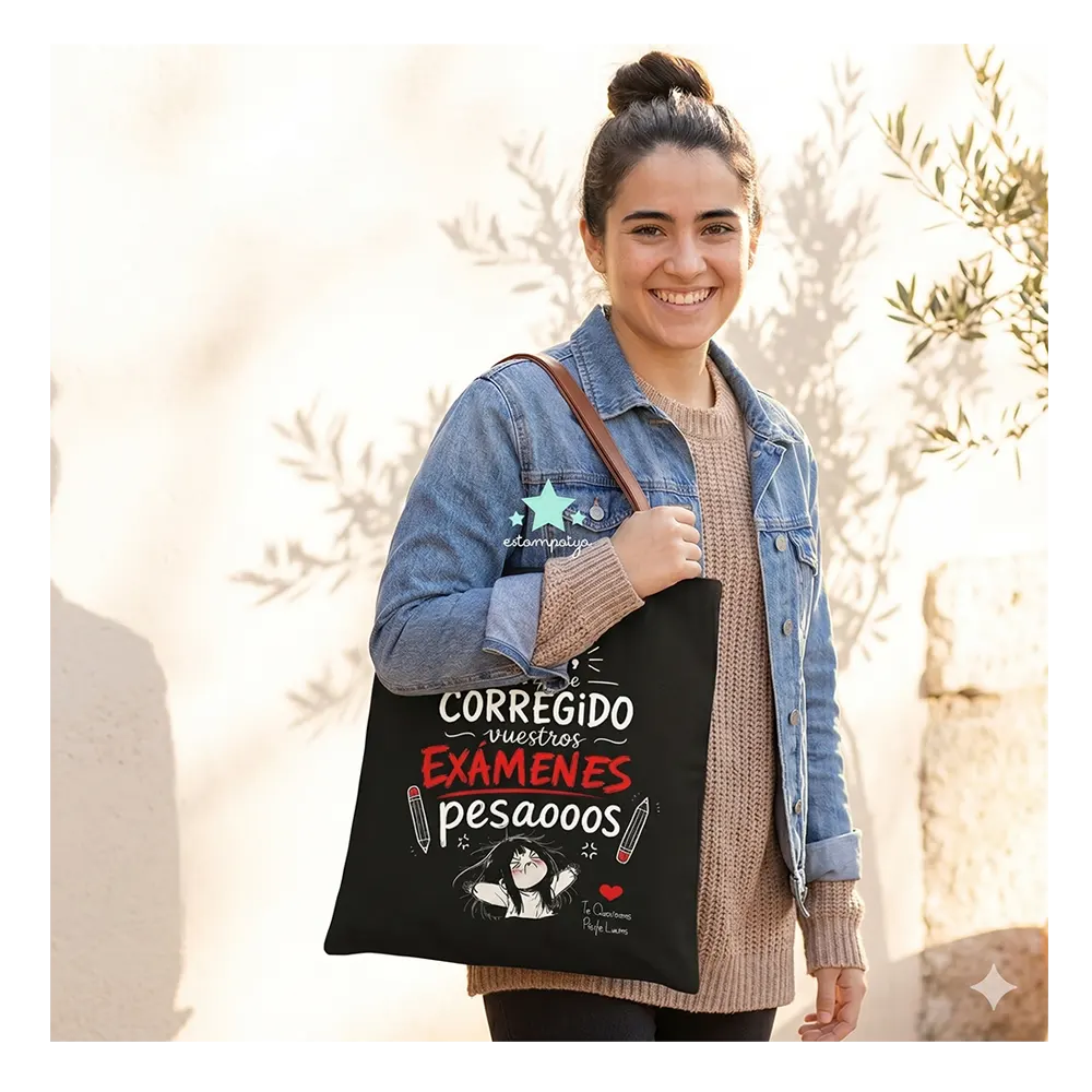 Bolsa de Tela Profe "No He Corregido los Exámenes" - Estampatya Bolsa de tela negra para profesora con frase divertida sobre corregir examenes y asas marrones, modelo la lleva puesta