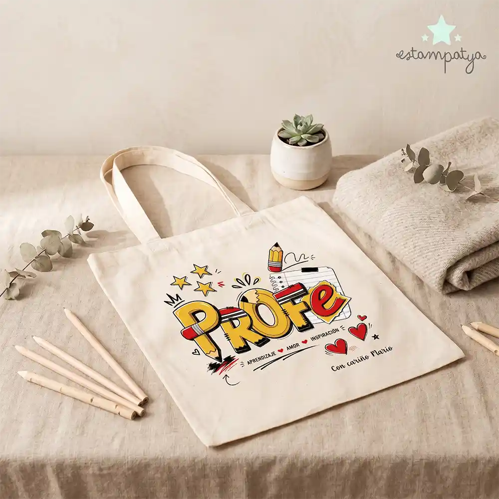 Bolsa Tote de Tela Personalizada "Profe Lápices" - Estampatya Tote bag premium de 340g para maestra personalizada con nombre de niño en un entorno escolar con material educativo.